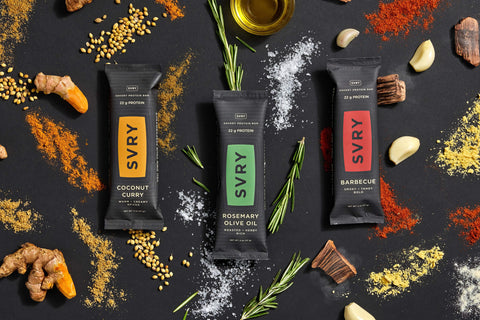savory protein bars on a dark background with spices and ingredients around them