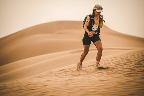 Person running on sand dunes in a desert setting