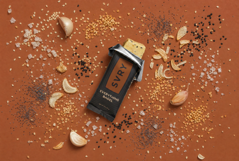 SVRY Everything Bagel Protein Bar on a surface with spices and seasonings