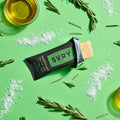SVRY rosemary olive oil protein bar with rosemary sprigs, olive oil and sea salt on a green background