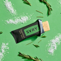 SVRY protein bar on a green background with rosemary leaves and salt crystals.